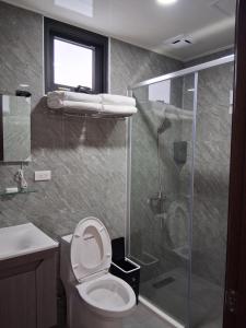 a bathroom with a toilet and a glass shower at Starry Night Travel Homestay in Magong +15 photos