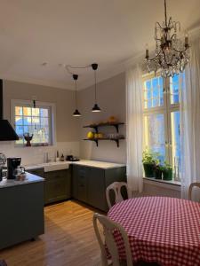a kitchen with a table with a red and white table cloth at Villa Thurdus in Härnösand
