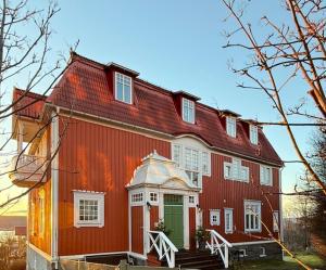 a red house with a red roof with a green door at Villa Thurdus in Härnösand