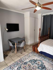 a bedroom with a table and a bed and a television at 899 On Burlington in Pretoria