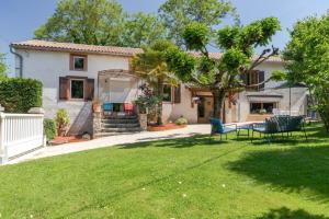 een tuin met stoelen en een tafel voor een huis bij Le ruisseau du bejean in Sainte-Gemme