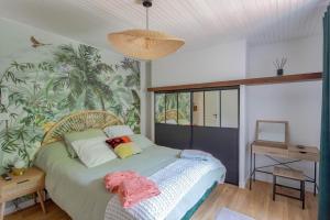 een slaapkamer met een bed en een muur met planten bij Le ruisseau du bejean in Sainte-Gemme +25 foto's