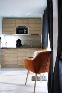 a kitchen with wooden cabinets and a chair at Suite Nordique - Cinéma et Jacuzzi in Bordeaux