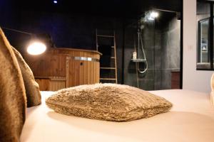a furry pillow sitting on a bed in a bathroom at Suite Nordique - Cinéma et Jacuzzi in Bordeaux