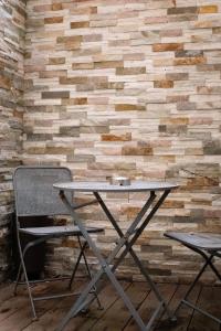 a table and two chairs in front of a brick wall at Suite Nordique - Cinéma et Jacuzzi in Bordeaux +3 photos