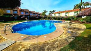 a large swimming pool with blue water in a yard at Pura Vida in Lepe