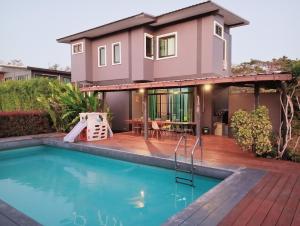 a house with a swimming pool in front of a house at บ้านฮิมฝั่งแกนพูลวิลล่า in Ban Pong (2)