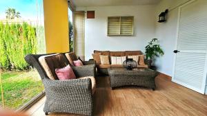 a living room with a couch and wicker chairs at Pura Vida in Lepe