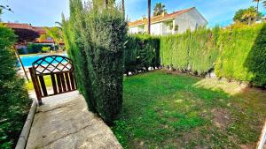 a garden with a gate and a hedge at Pura Vida in Lepe +58 photos