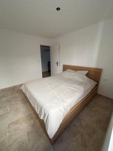 a bedroom with a large bed with white sheets at La maison du Quart - Maison de village in Sommières