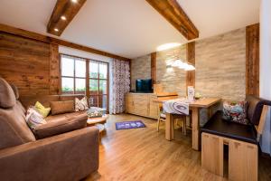 un soggiorno con divano, tavolo e scrivania di Landhaus Pichler a Tannheim
