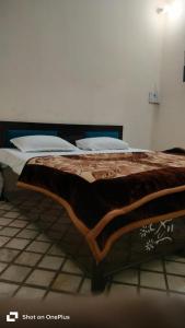 a bed with a brown blanket on top of it at Hotel Aarav Inn in Pānīpat