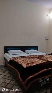 a bedroom with a large bed with a blanket on it at Hotel Aarav Inn in Pānīpat