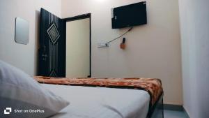 a bedroom with a bed and a door with a television at Hotel Aarav Inn in Pānīpat