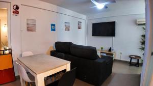 a living room with a black couch and a table at Apartalux Vera Rincón de Loix in Benidorm