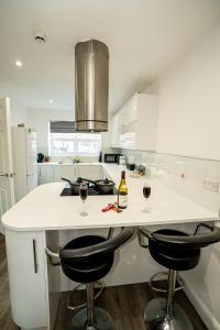 una cucina bianca con due bicchieri di vino su un bancone di Queens Court Ensuite Studio a Stoke on Trent