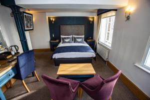 een hotelkamer met een bed en twee stoelen bij Ennios Boutique Hotel in Southampton
