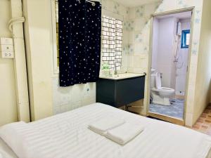 a bedroom with a bed and a sink and a toilet at BKK Rama3 Guest House in Bangkok