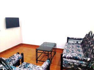 een woonkamer met 3 banken en een tafel bij Nhanji House in Arambol