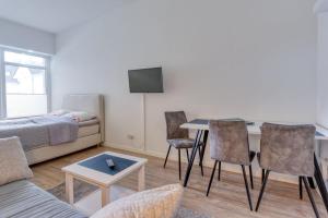 een woonkamer met een bank, een tafel en stoelen bij Alte Teestube 55 in Norderney