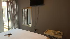 a bedroom with a bed and a television on the wall at K K K Guesthouse in Secunda