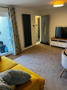 ein Wohnzimmer mit Sofa und Flachbildfernseher in der Unterkunft Witz End in Corsham
