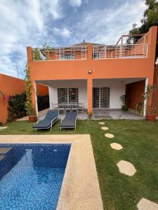 een huis met een zwembad ervoor bij Villa John et Nini in Saly Portudal