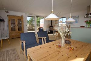 una cucina e un soggiorno con tavolo e sedie in legno di Lovely Summer House On Natural Grounds a Frøstrup