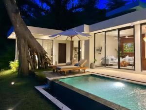 a villa with a swimming pool at night at 3BR Tala Villa Ubud in Ubud