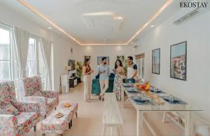 een groep mensen die in een woonkamer staan bij EKOSTAY Gold - Ark Stone Villa in Alibaug