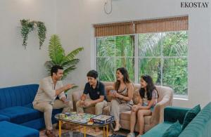 een groep mensen die op een bank zitten bij EKOSTAY Gold - Ark Stone Villa in Alibaug +23 foto's