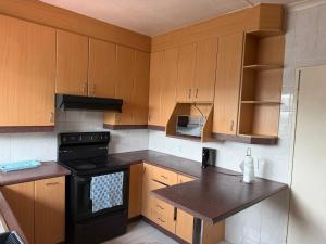 a kitchen with wooden cabinets and a black stove at Crest Premium in Johannesburg