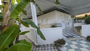 a white house with a black and white checkered floor at Casa vacanze Lu Salentu in Torre Lapillo