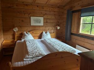a bedroom with a bed in a log cabin at Private Swedish Forest Cabin in Ulricehamn