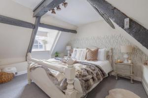 a bedroom with a white bed and a window at Olive Cottage in Swanage