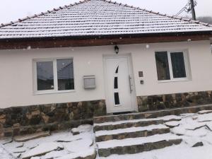 a house with a white door in the snow at Caraiman House in Sighişoara