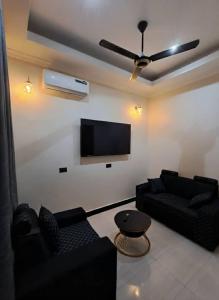 a living room with black furniture and a flat screen tv at Serengeti space resort in Bunda +7 photos