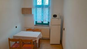 a small kitchen with a table and a white refrigerator at Apartmány SRC in Nové Město pod Smrkem