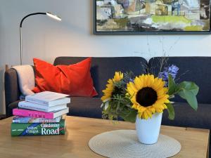 a vase with a sunflower on a table with books at Kapitän Hansen Haus in Kosel