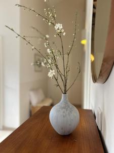 a white vase with flowers in it on a table at Kapitän Hansen Haus in Kosel