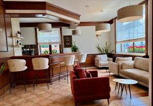 een woonkamer met een bar met een bank en stoelen bij Hotel Basztowy in Sandomierz