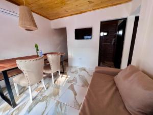 a living room with a couch and a table and chairs at Cabañas Rincón Andaluz in Puerto Iguazú