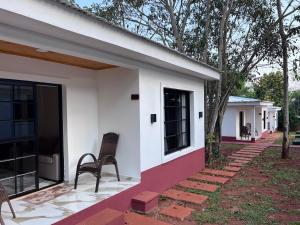 a house with two chairs sitting outside of it at Cabañas Rincón Andaluz in Puerto Iguazú