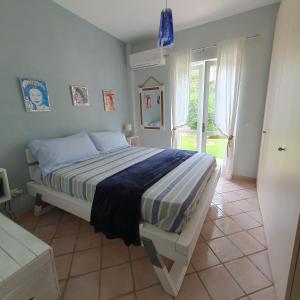 een slaapkamer met een bed met een blauw-witte deken bij Casa Guido in Cittadella del Capo