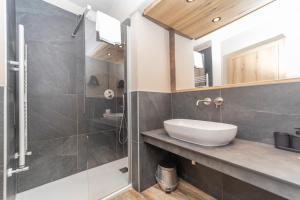 a bathroom with a sink and a shower at Hotel la Torre in Sauze dʼOulx +46 photos