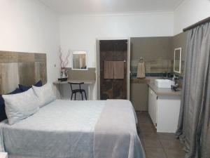 a bedroom with a bed and a small kitchen at Aub Guesthouse - Mariental in Mariental