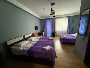 a hotel room with two beds with purple sheets at Hotel Hills in Bakuriani