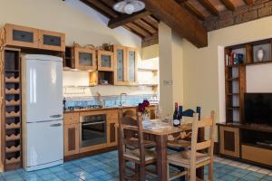 a kitchen with a white refrigerator and a wooden table at Le Dimore by Borgo Tessile - Feronia in Orvieto +28 photos