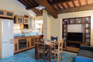 a kitchen with a table and a white refrigerator at Le Dimore by Borgo Tessile - Feronia in Orvieto
