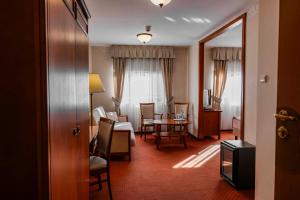 een hotelkamer met een tafel en stoelen en een kamer bij Hotel Basztowy in Sandomierz +70 foto's